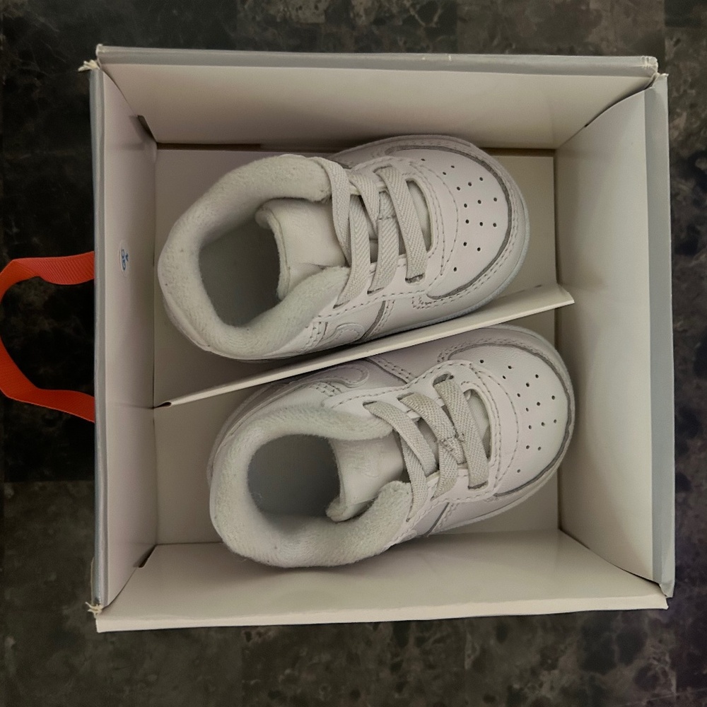 White Nike Air Force 1 crib shoes.
